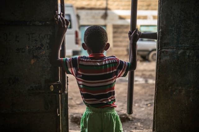 child looking out the door